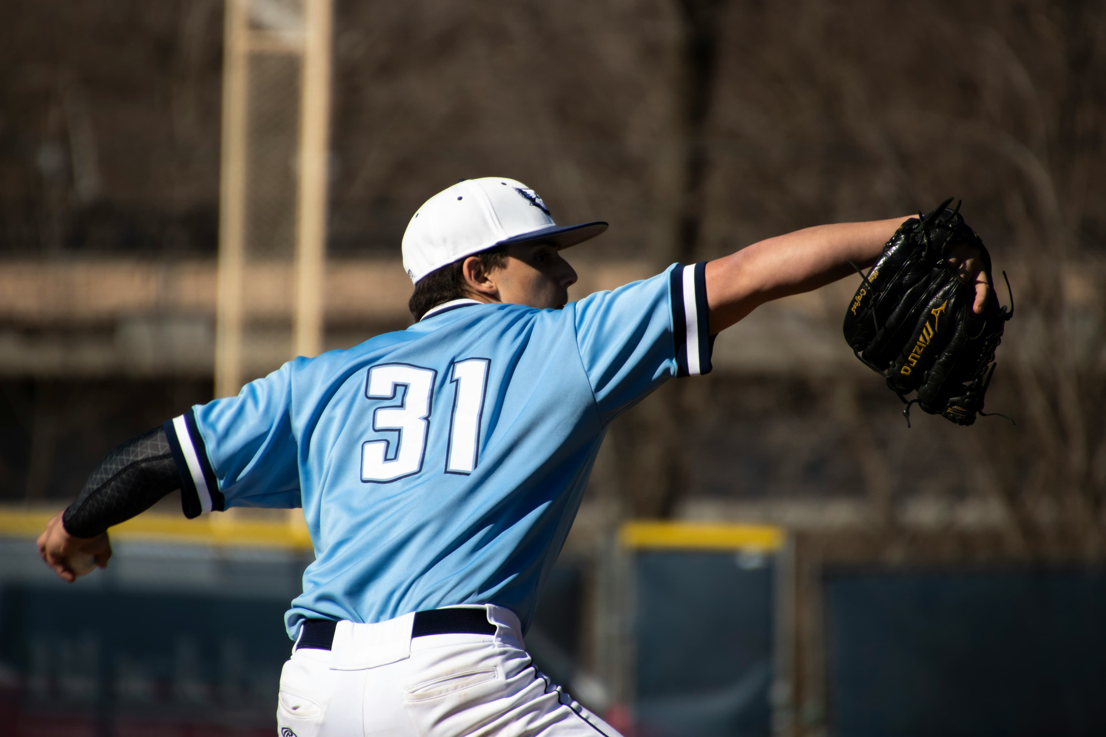 NJCAA Baseballspieler in blauer Uniform beim Schlag während eines Junior College Spiels