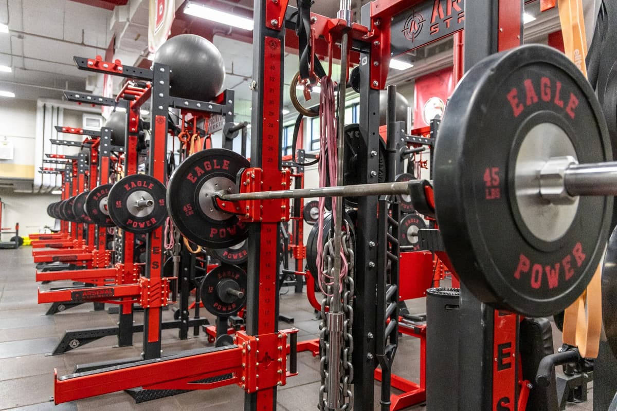 A swimmer has started the race, shortly before diving into the water. College swimmer diving.